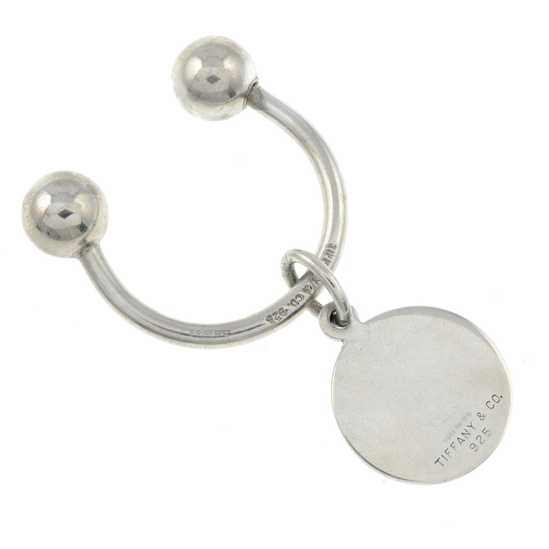 A silver key ring with charm, by Tiffany & Co.Signed Tiffany & Co.