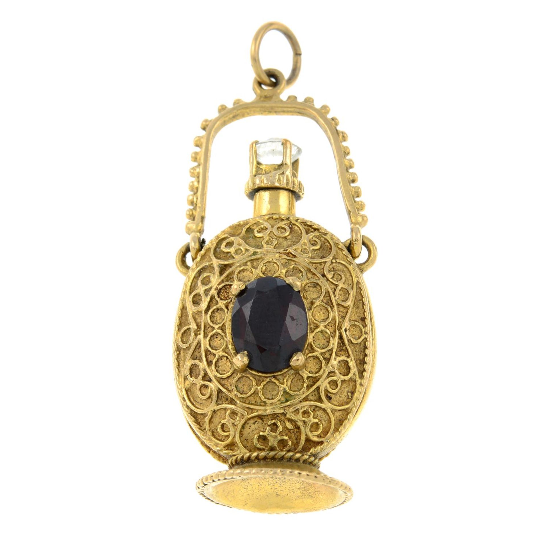 A bottle pendant, with garnet and colourless gem accent.Length 5.2cms.