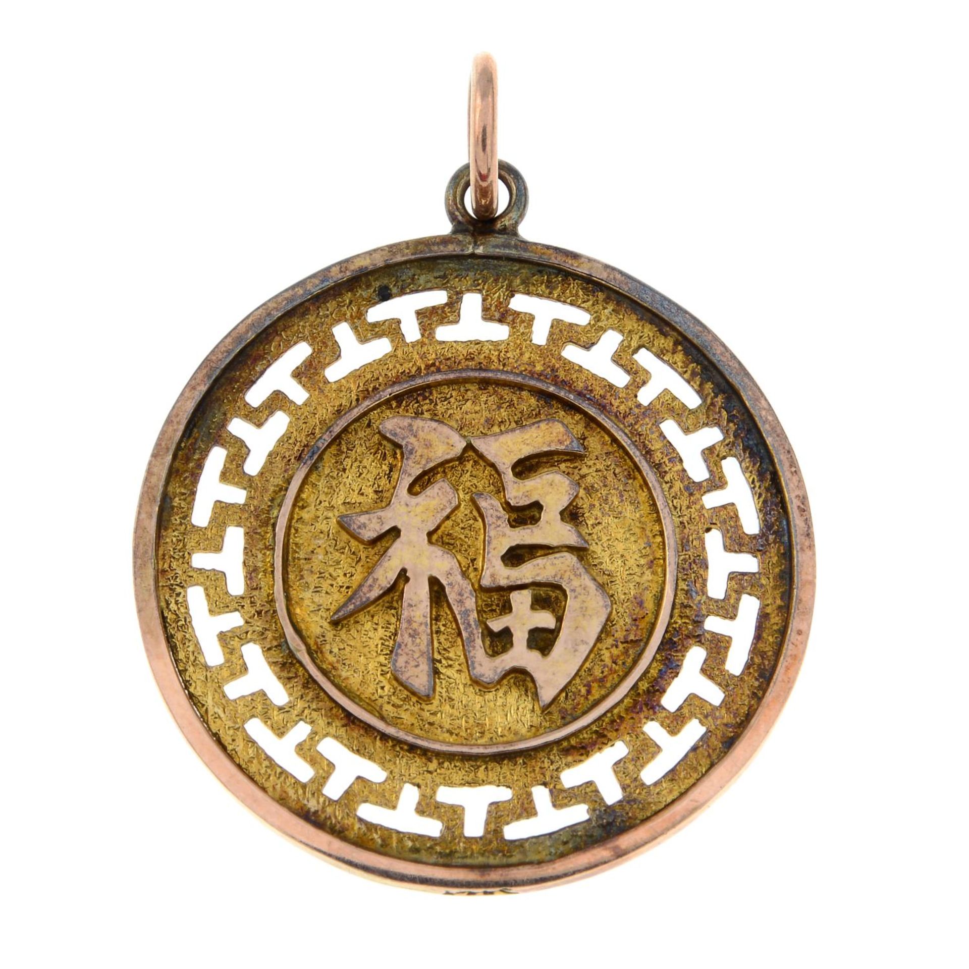 A circular pendant, with oriental character motif.Stamped 14k.Diameter 2.5cms.