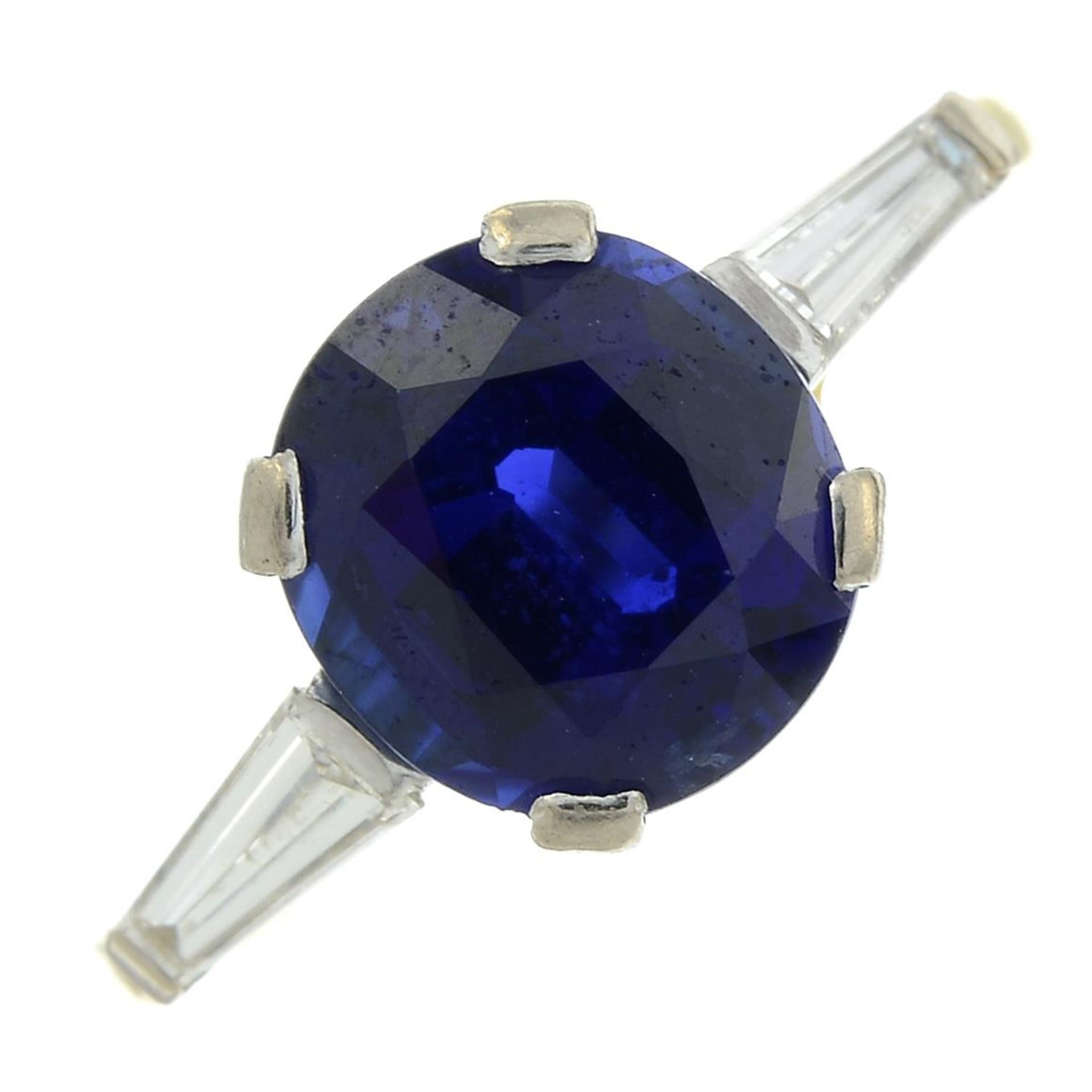 A sapphire and baguette-cut diamond three-stone ring.Sapphire calculated weight 2.09cts,