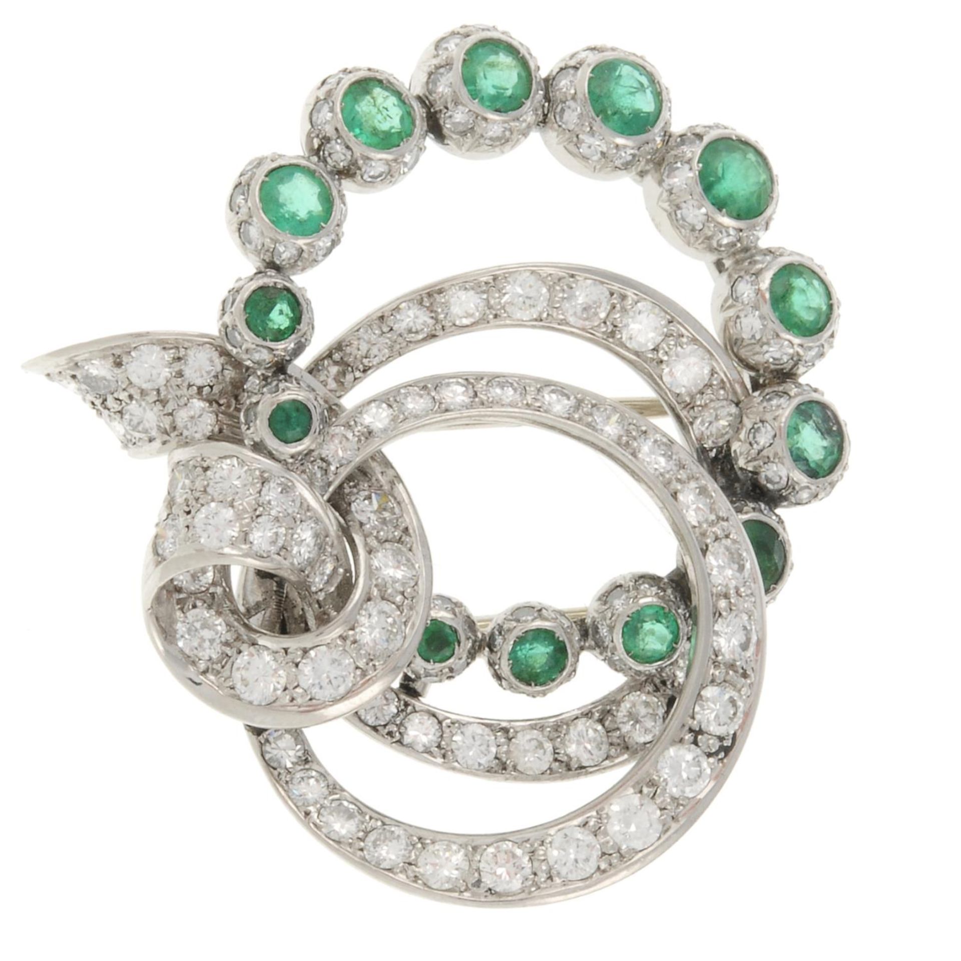 An emerald and vari-cut diamond brooch.Estimated total diamond weight 1.75cts.Stamped 750.Length