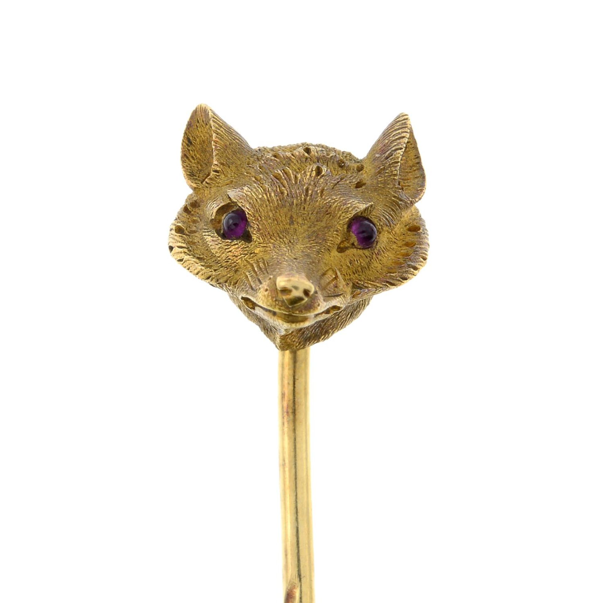 A late 19th century gold fox mask stick pin, with ruby eye detail.Length of stick pin head 0.9cm.