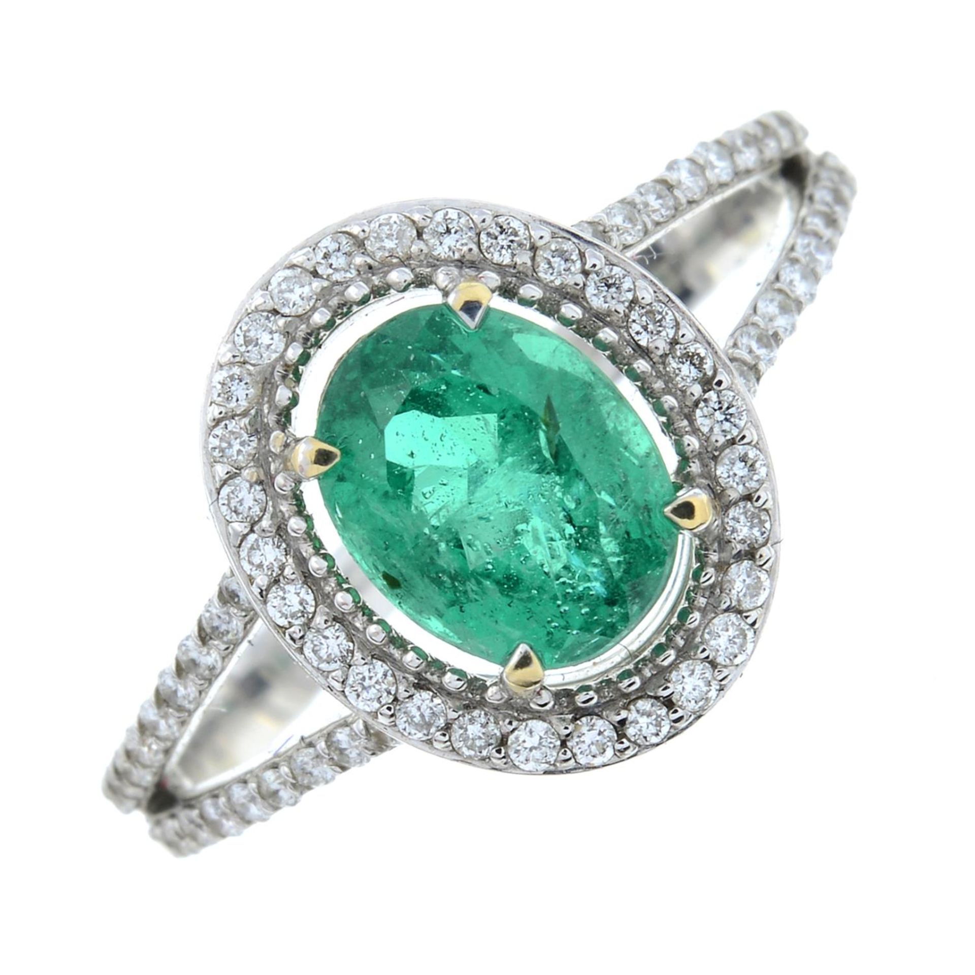 An emerald and brilliant-cut diamond cluster ring.Emerald calculated weight 1,