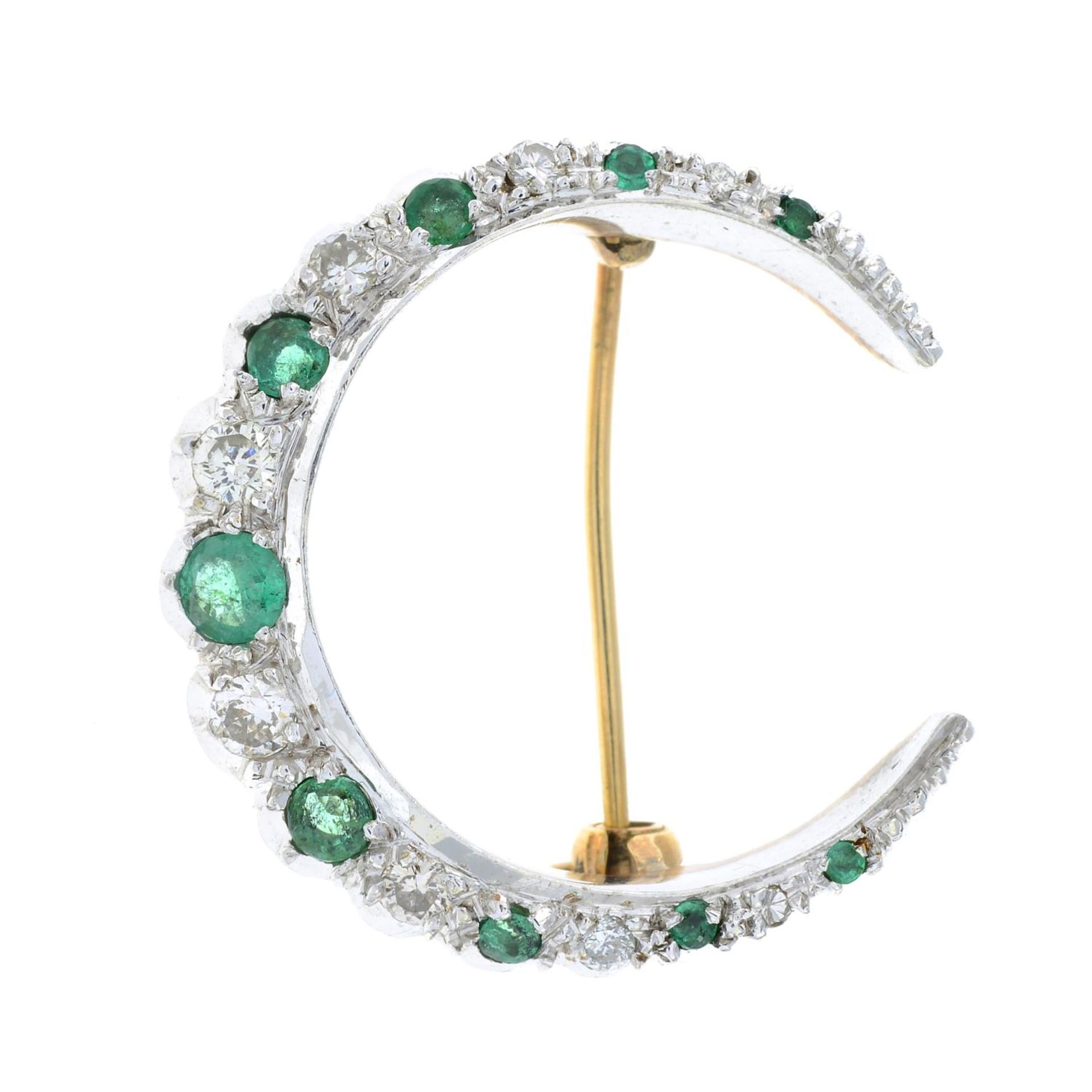 A 9ct gold emerald and brilliant-cut diamond crescent moon brooch.Estimated total diamond weight