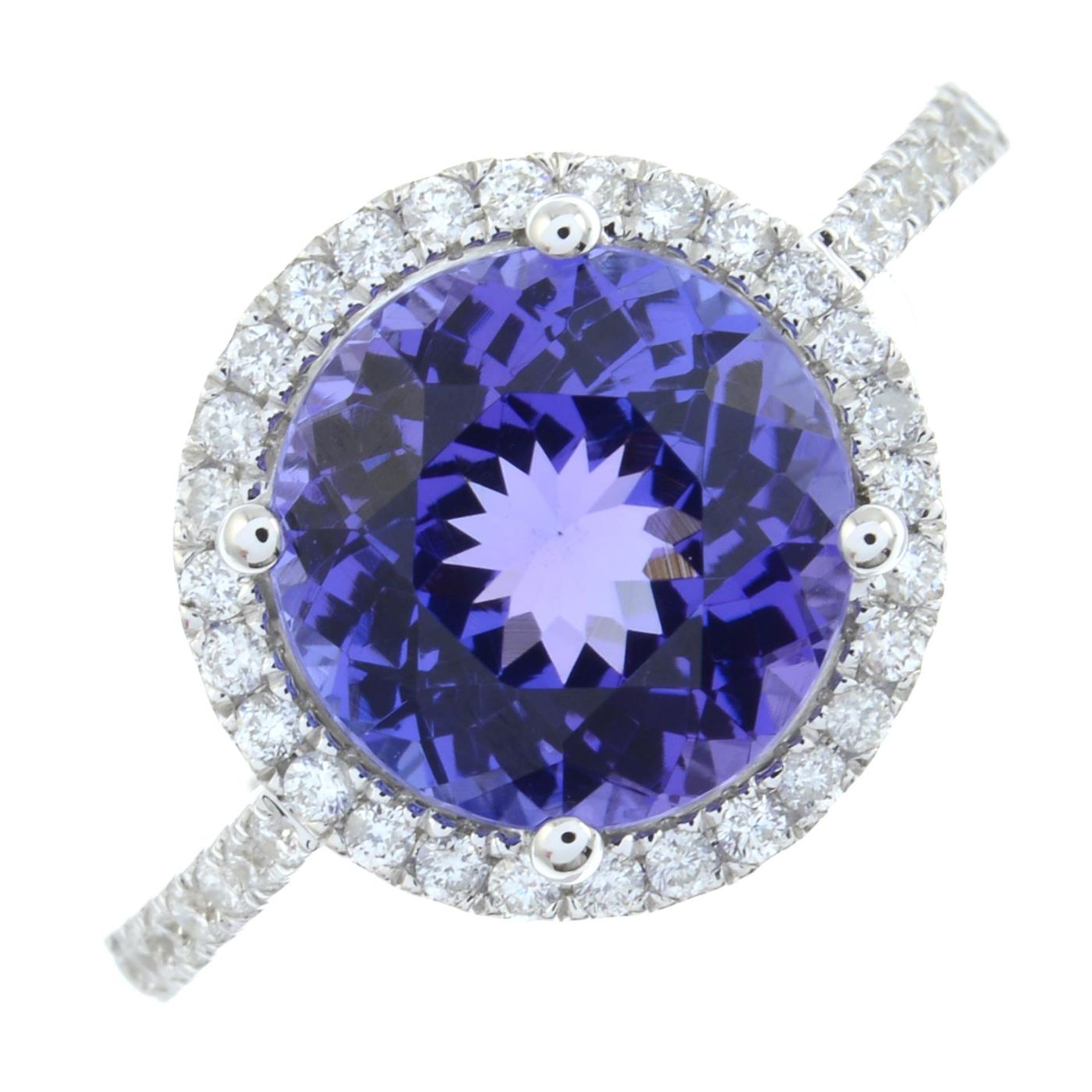 An 18ct gold tanzanite and brilliant-cut diamond cluster ring.Tanzanite weight 3.60cts.Total