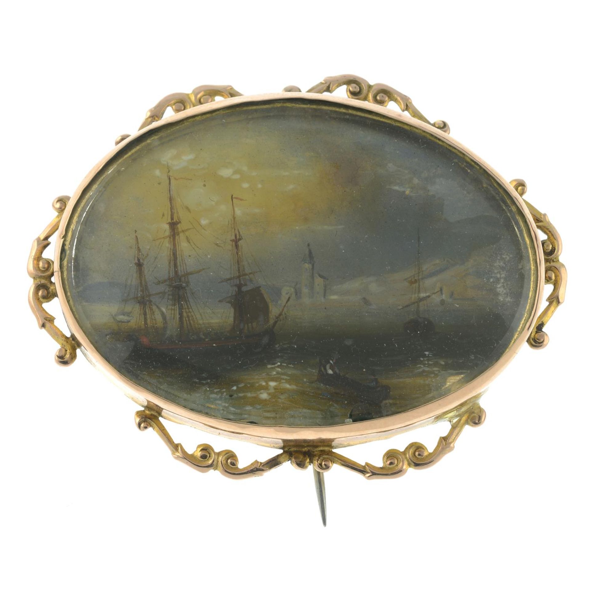 A late 19th century gold mounted brooch, with painted sailing scene, behind glass.Length 5.3cms.