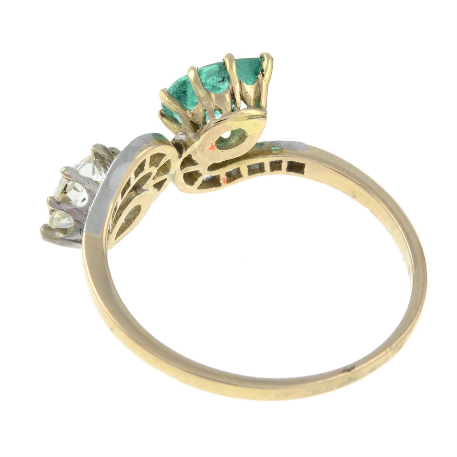 A vari-cut diamond and emerald crossover ring. - Image 2 of 2