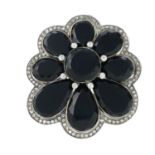 An onyx and diamond floral brooch.