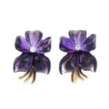 A pair of carved amethyst and diamond clip-on earrings of violet flowers.