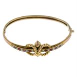 An early 20th century 9ct gold ruby and split pearl hinged bangle.