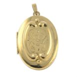 A gold locket with engraved floral motif.