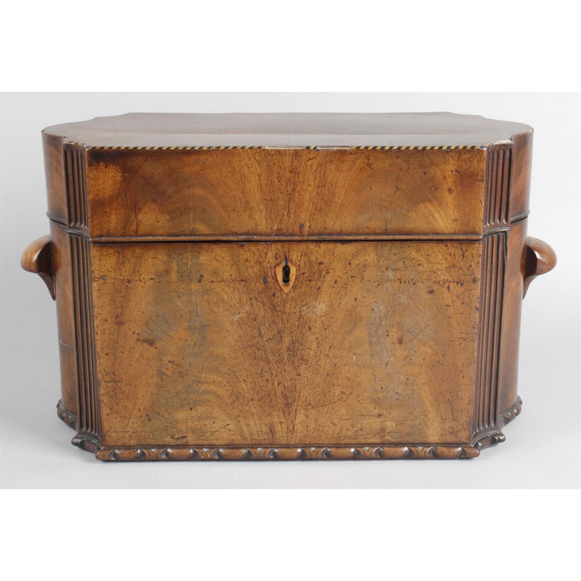 A 19th century mahogany veneered tea caddy, together with an Edwardian inlaid mahogany book trough.