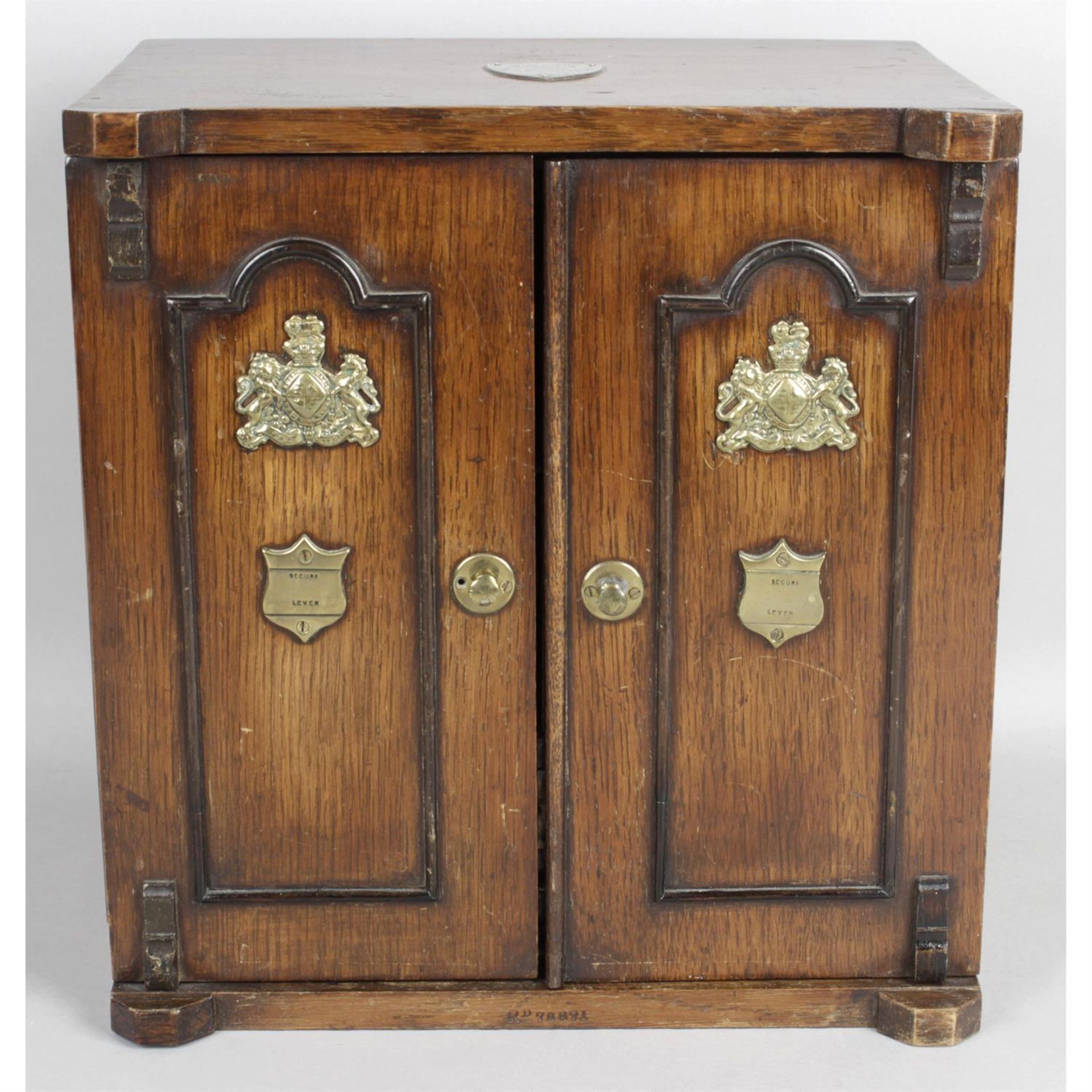 A late 19th century novelty oak smokers cabinet modelled as a twin door safe