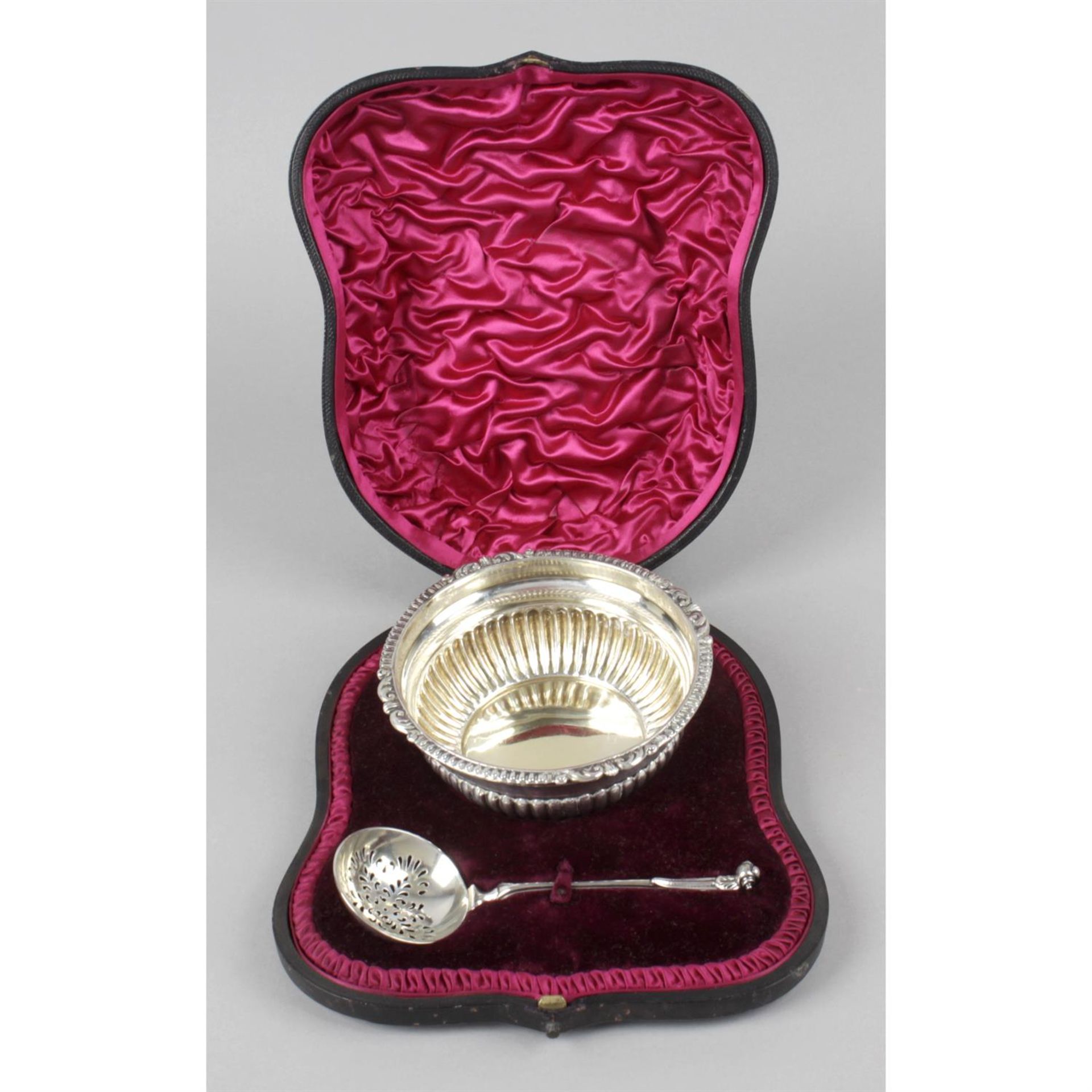 A late Victorian silver sugar bowl and sifter spoon, in fitted case.