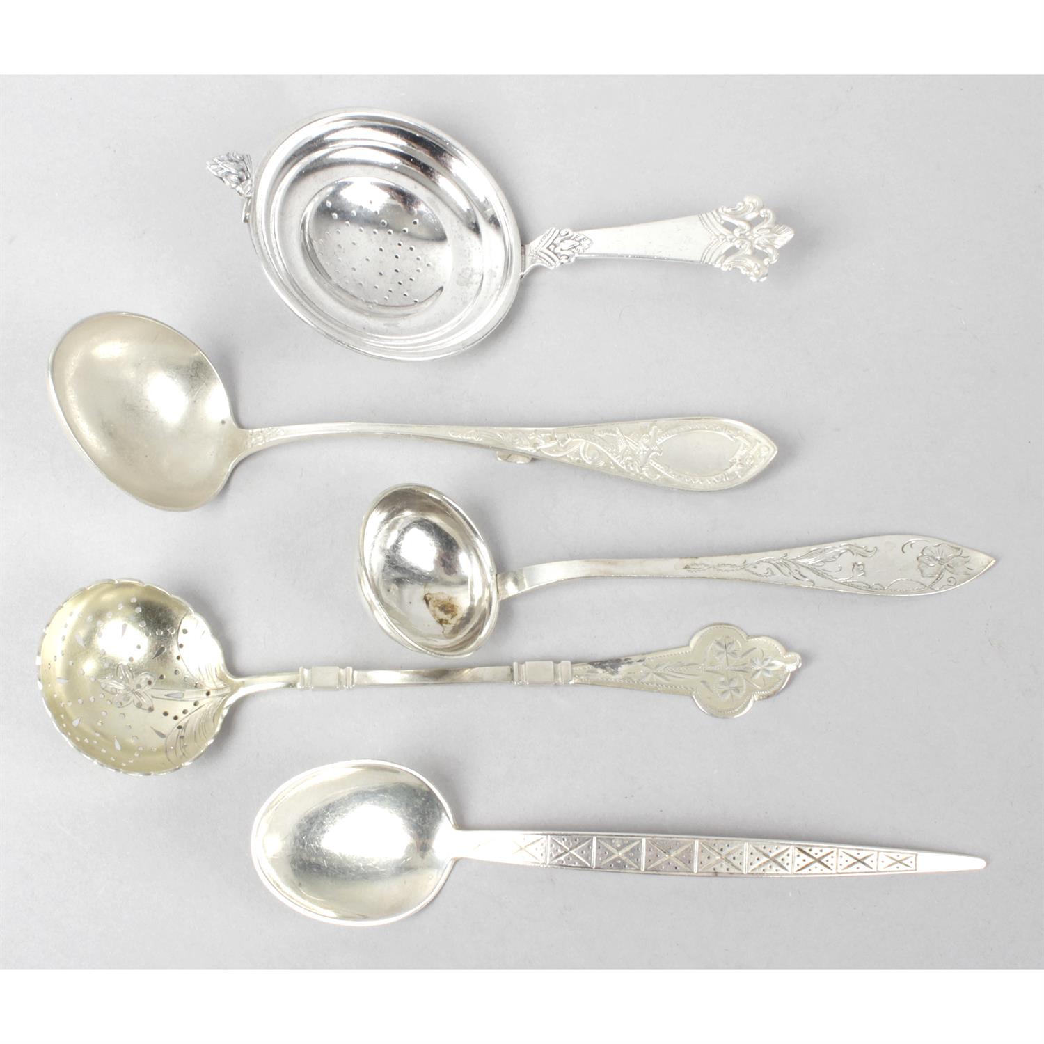 A miscellaneous selection of small spoons, plus a butter knife, tea strainer and four assorted