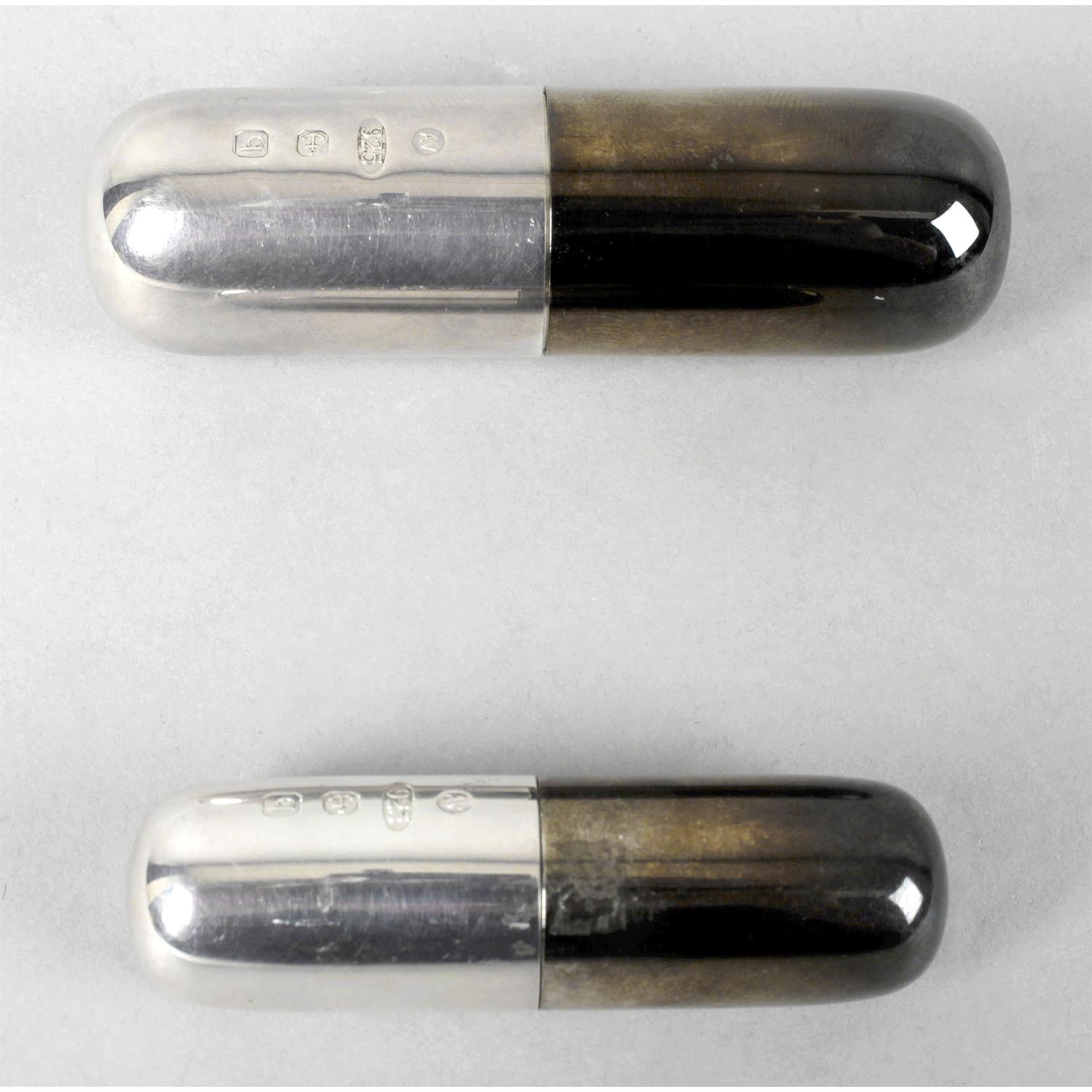 Two silver pill boxes modelled as pill capsules.