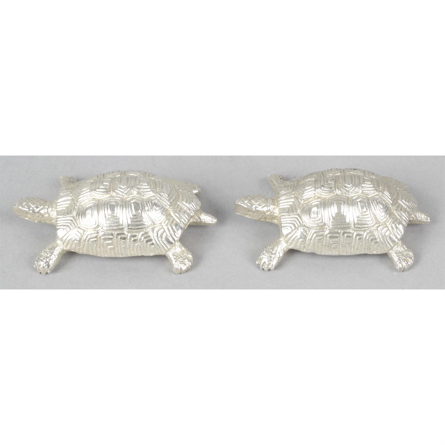 Two silver figurines modelled as tortoises.