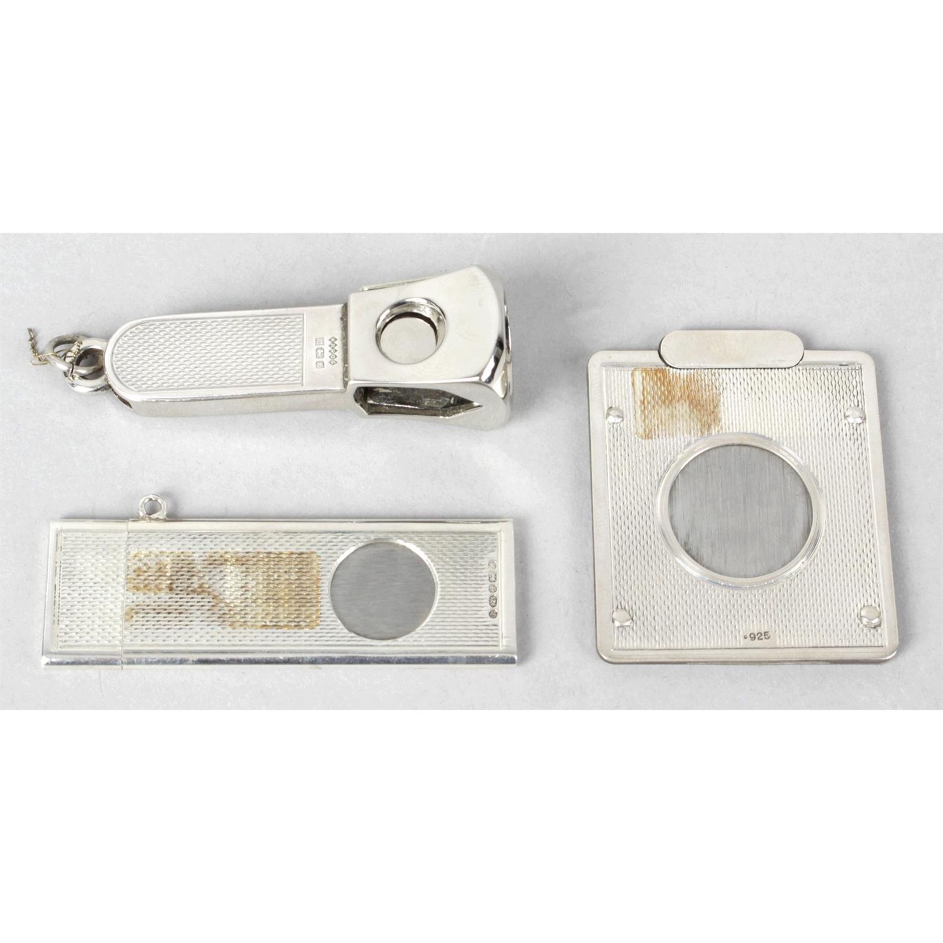 Three silver mounted cigar cutters.