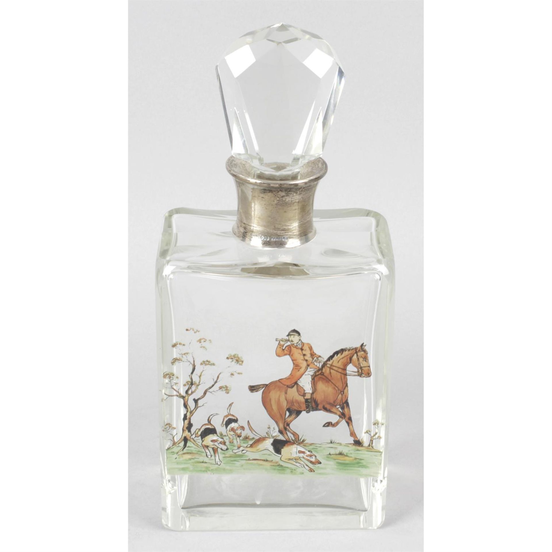 A glass decanter and stopper with hunting scene & silver collar mount.