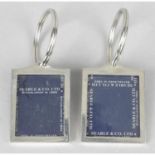 Two silver key rings designed as photograph frames.