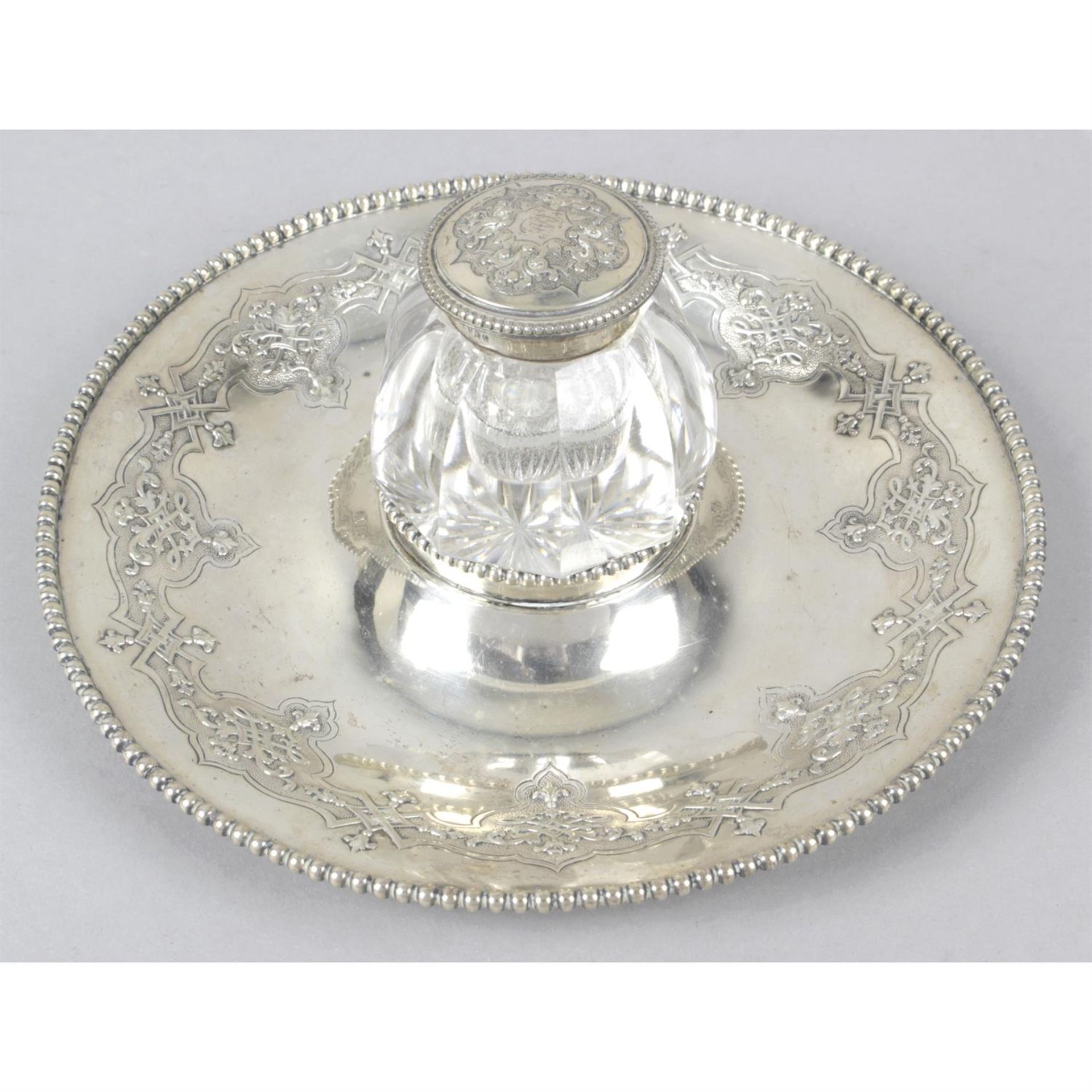 A Victorian silver inkstand with central glass ink pot.