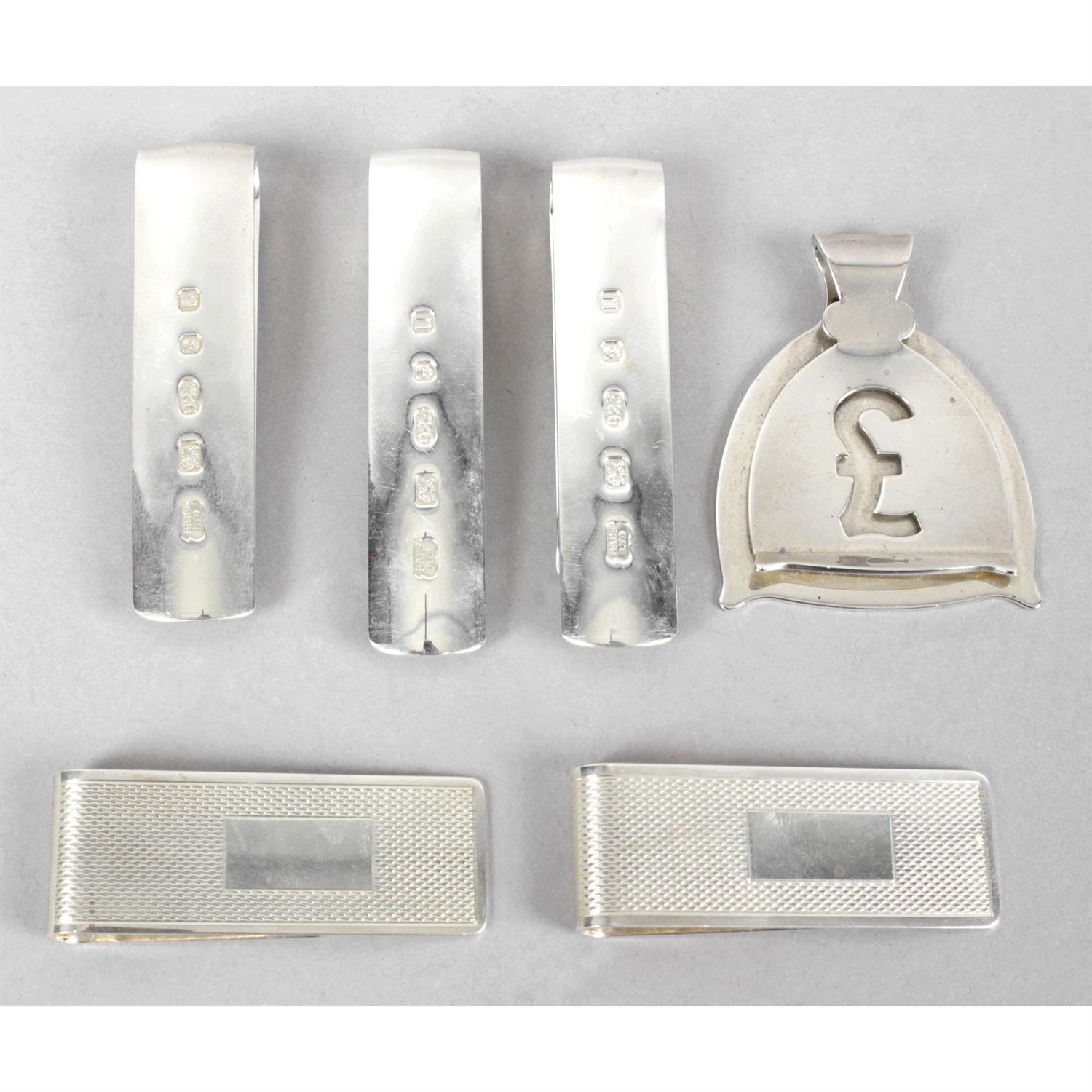 Six silver money clips of various forms.