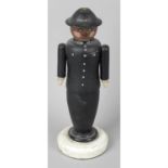 A carved and painted wooden folk art lamp base modelled as a police officer.