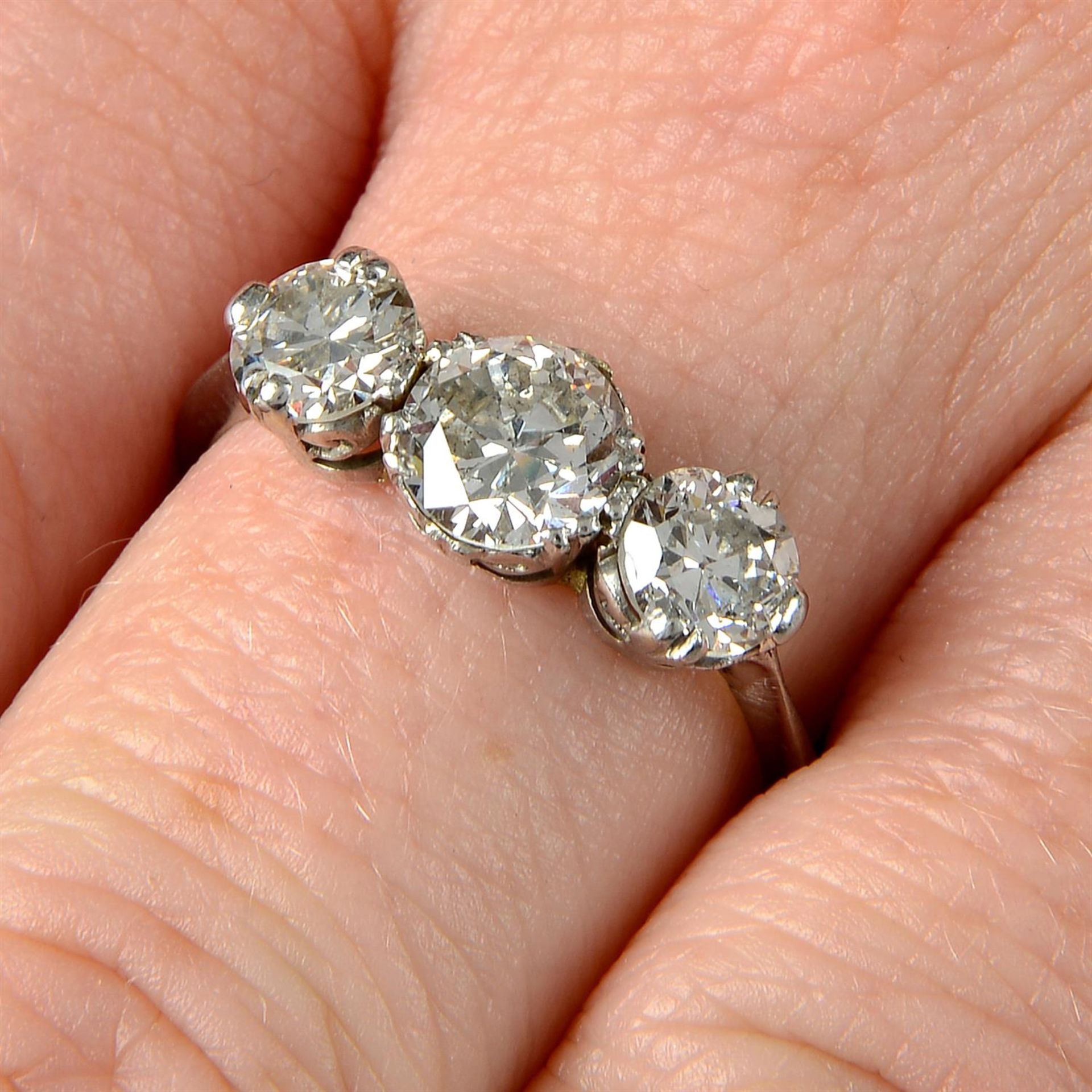 A mid 20th century platinum, graduated diamond three stone ring.