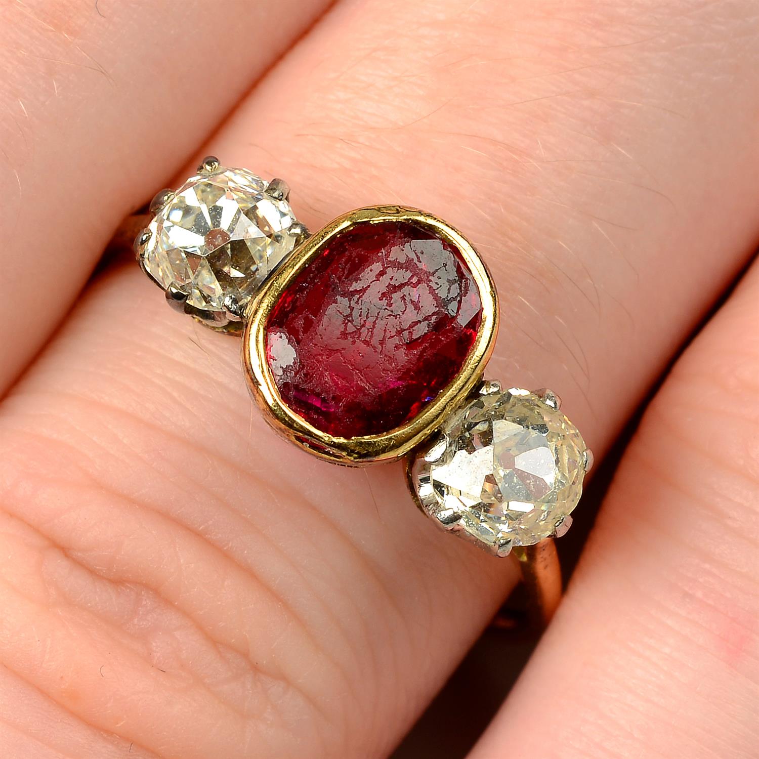 A ruby and diamond three-stone ring.