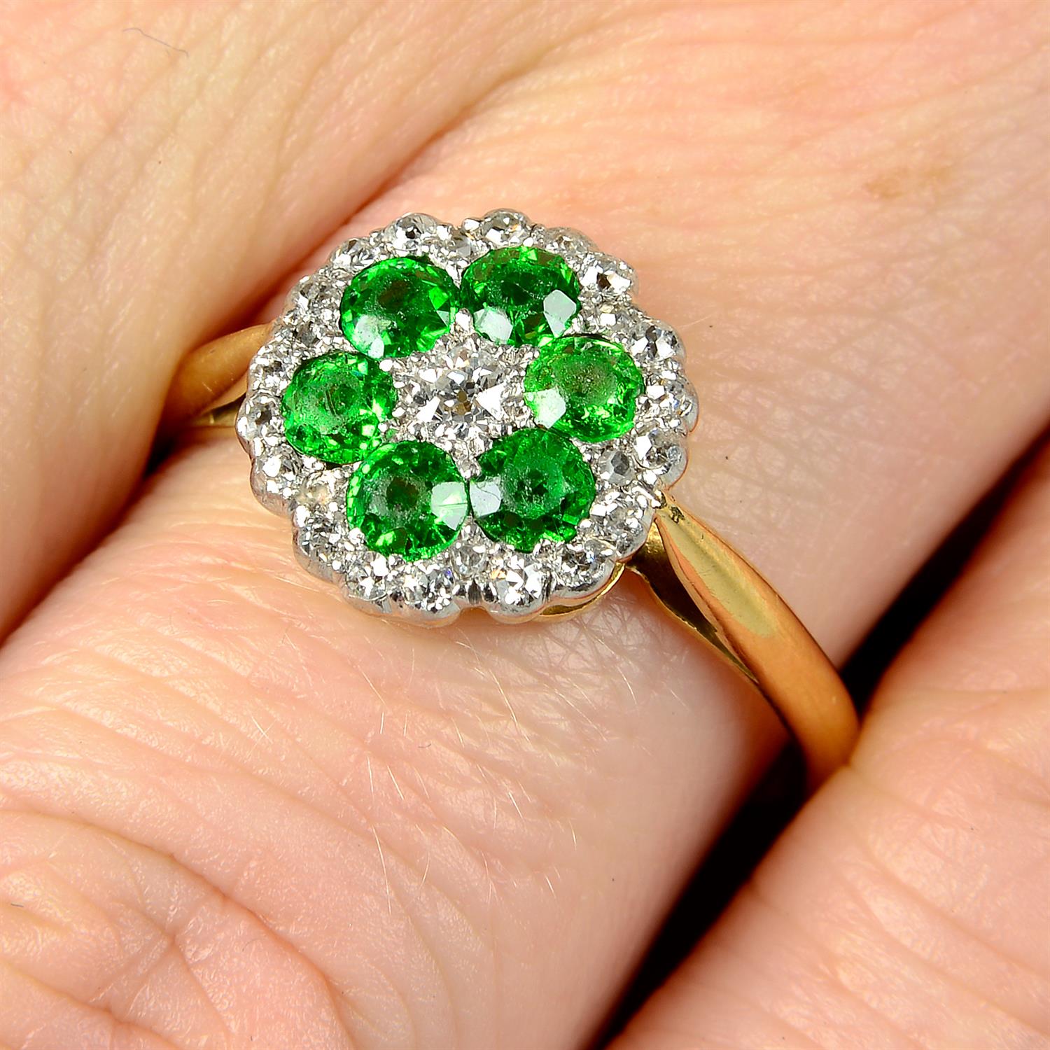 An early 20th century 18ct gold diamond and demantoid garnet cluster ring.