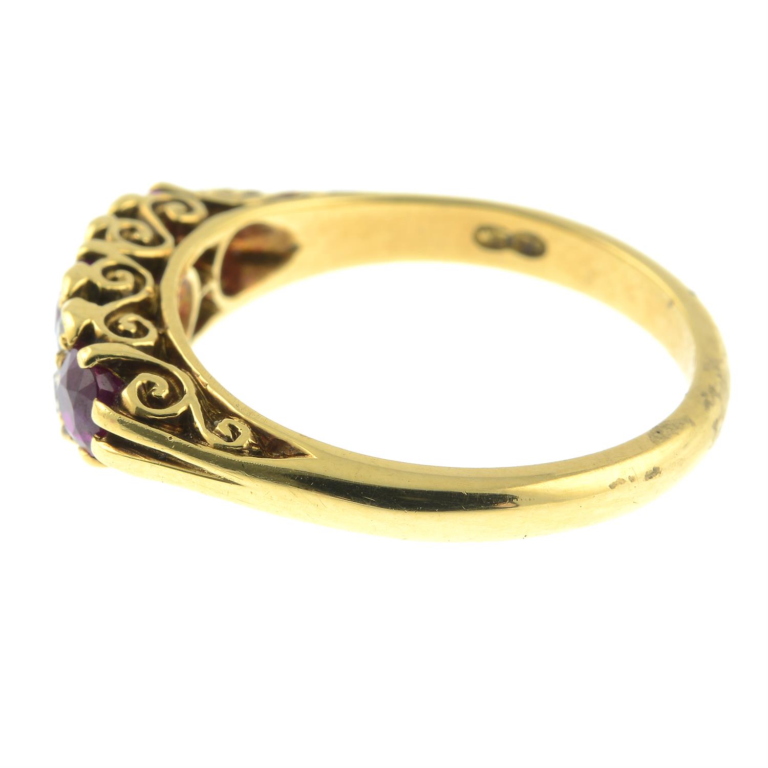 An 18ct gold slightly graduated ruby three-stone ring, with diamond double spacers and scrolling - Image 3 of 6