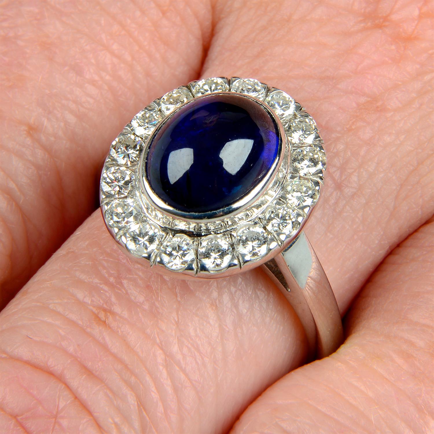 An 18ct gold sapphire cabochon and brilliant-cut diamond ring.