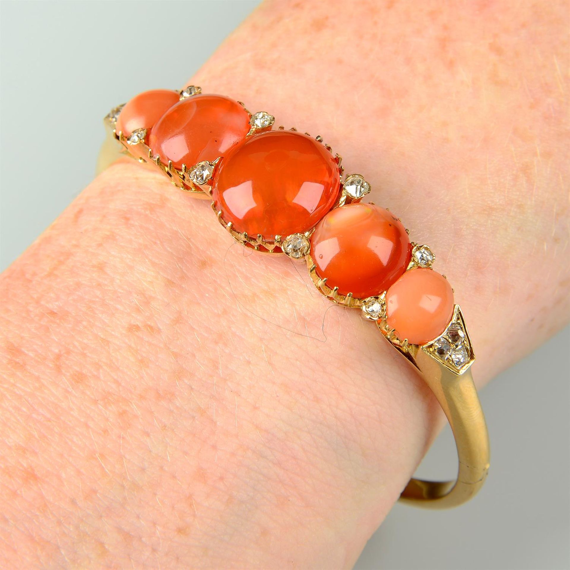 A late Victorian 18ct gold graduated fire opal and diamond hinged bangle.