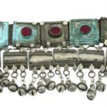 A Rashaida tribal belt with leather strap, red glass and suspended bells detail. AF.