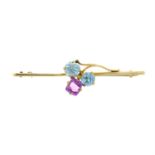 An early 20th century 9ct gold, blue zircon and pink-gem clover bar brooch.