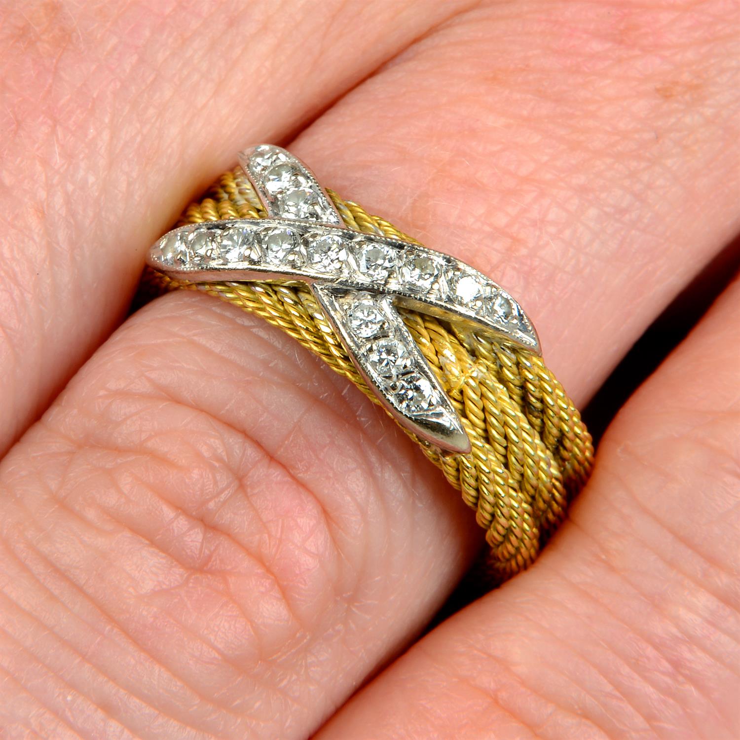 A rope-twist band ring, with pavé-set diamond cross highlight.