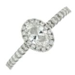 A platinum oval-shape diamond ring, with brilliant-cut diamond surround and sides.