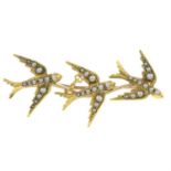 An early 20th century gold split pearl bar brooch, designed to depict three swallows in flight.