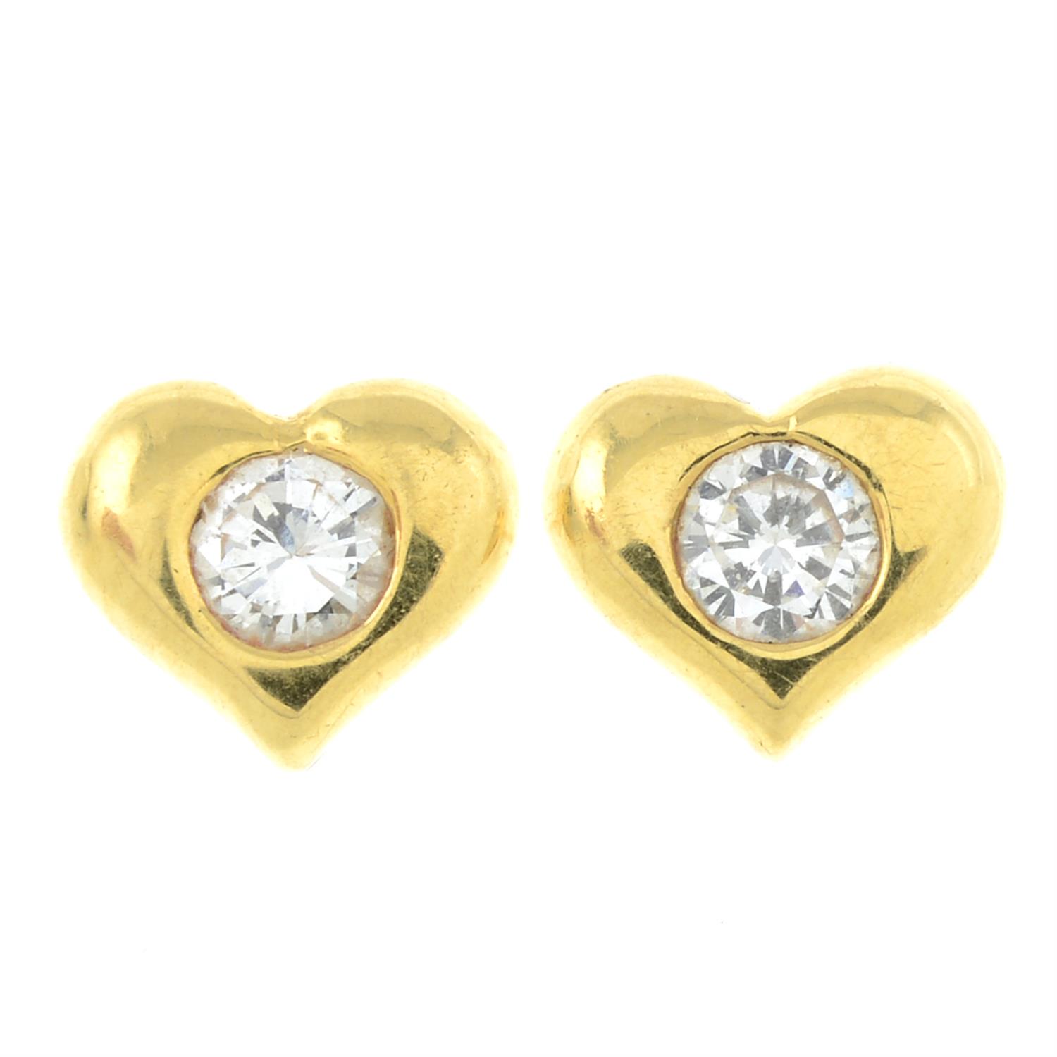 A pair of brilliant-cut diamond heart-shape stud earrings.