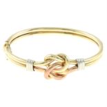 A 9ct gold tri-colour bangle, depicting a knot.