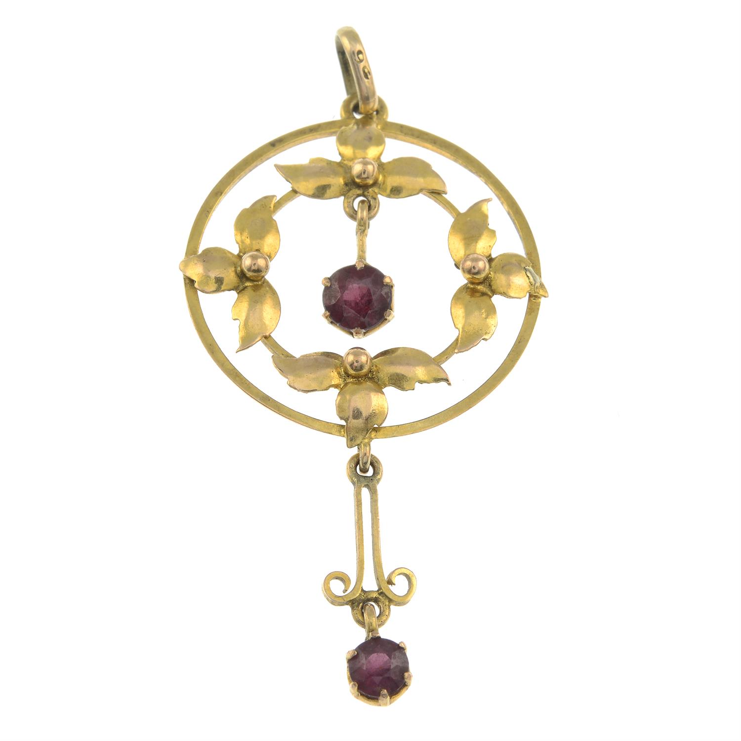 An early 20th century gold garnet accent pendant.