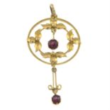 An early 20th century gold garnet accent pendant.