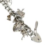 A curb-link charm bracelet, suspending fourteen charms, gathered at a heart-shape padlock clasp.