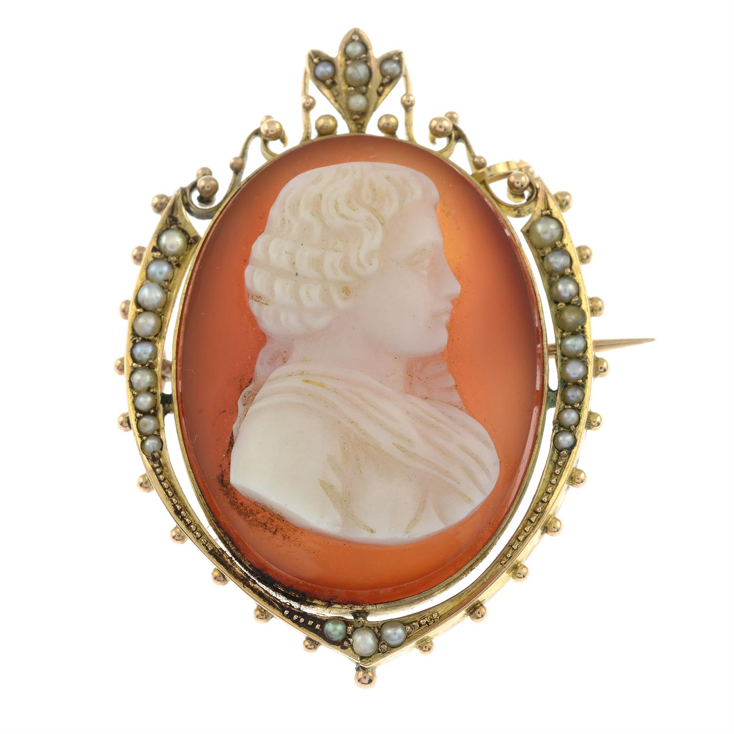 An early 20th century gold carnelian cameo and split pearl brooch, carved to depict a gentleman in