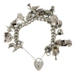 A silver curb-link charm bracelet, suspending fourteen charms, gathered at a heart-shape padlock