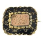 A mid Victorian gold and black enamel mourning brooch.