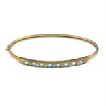 A 9ct gold topaz and single-cut diamond hinged bangle.