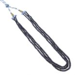 A three-row sapphire bead necklace.