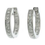 A pair of brilliant-cut diamond hoop earrings.