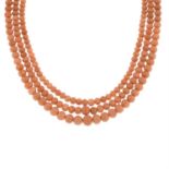 A three-row coral bead necklace.